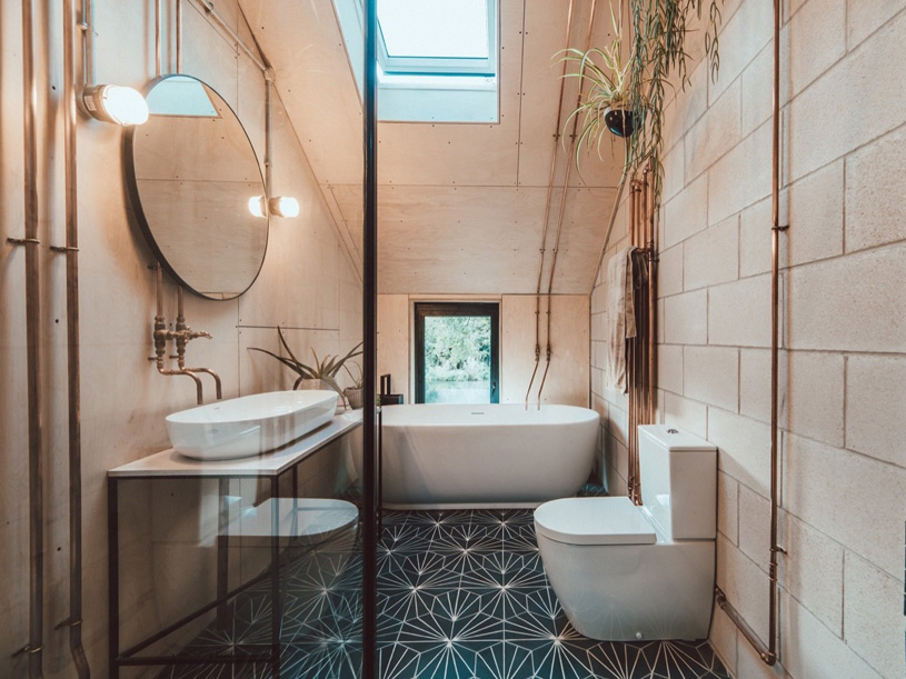 дизайн интерьера ванной комнаты с открытым расположением медных водопроводных труб